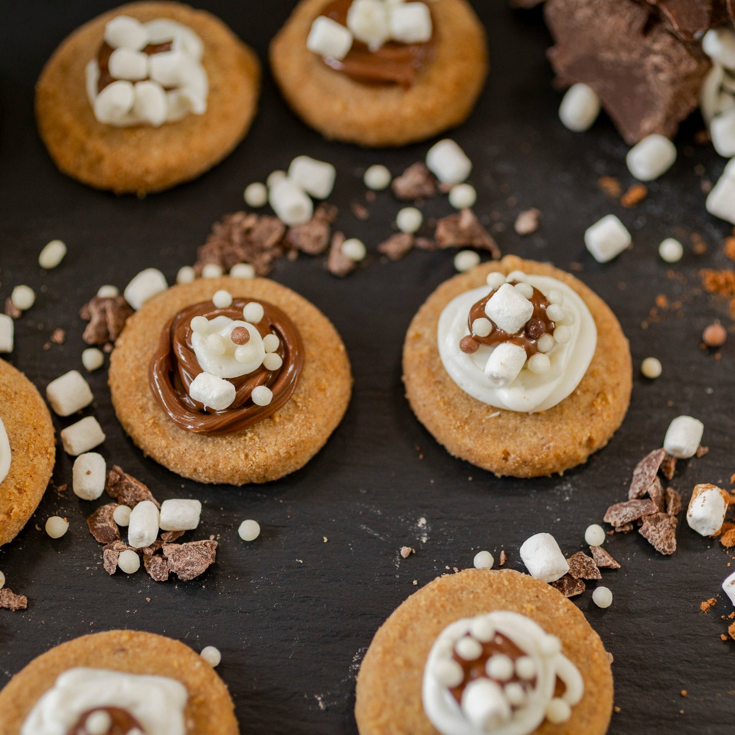 Cookies with marshmallows and chocolate on a dark surface